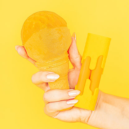 Hand holding a yellow ice cream cone against a yellow background